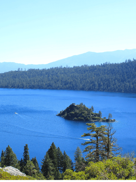 view of emerald bay in lake tahoe with two boats circling around the island